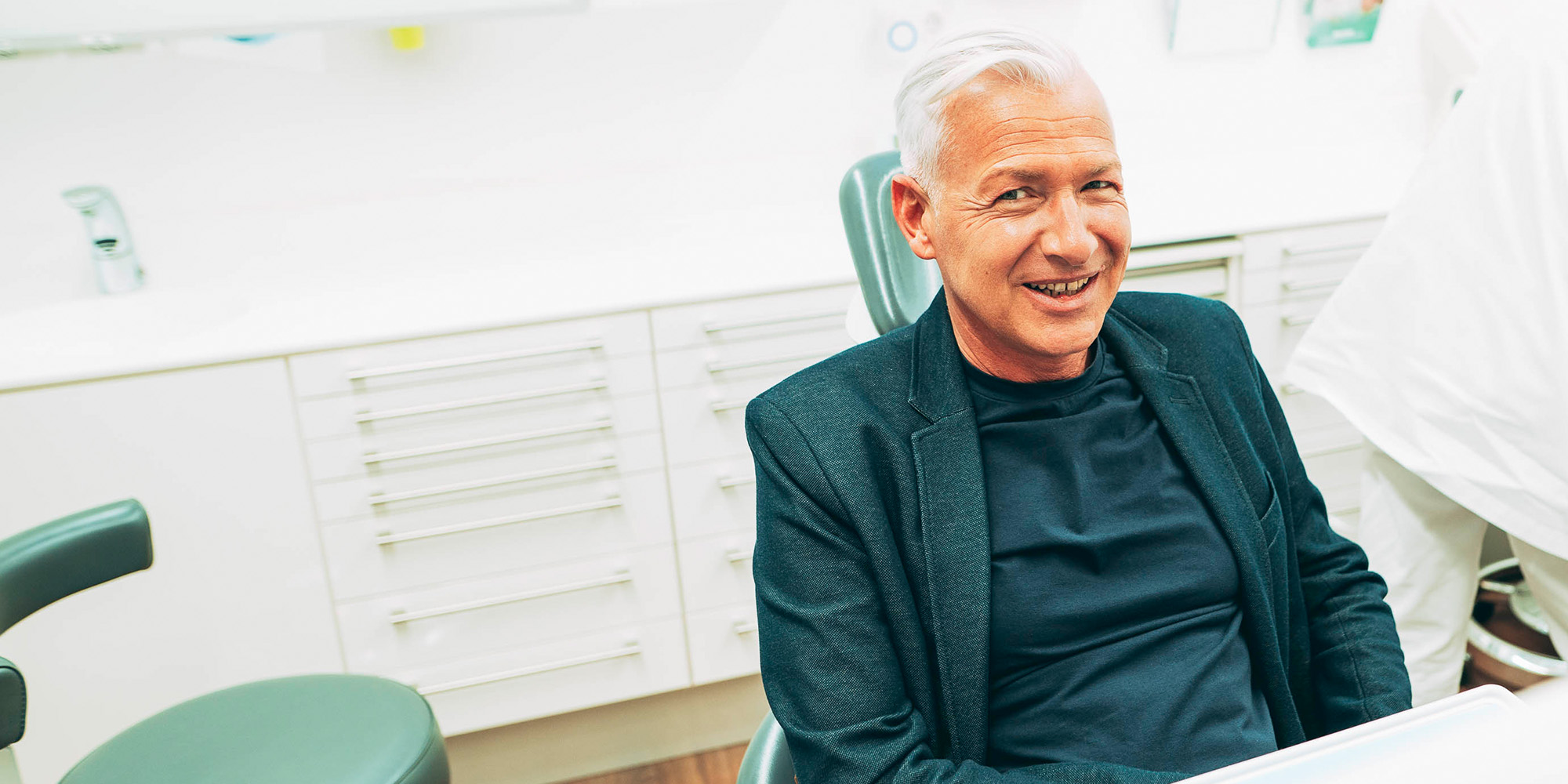 Mann freut sich über neue Keramikzähne aus Laupheim.